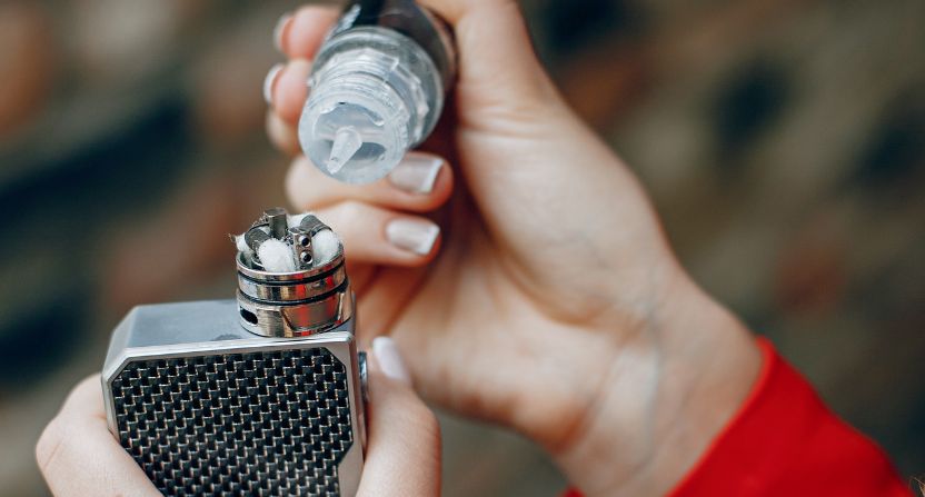 Personne qui met du eliquide dans sa cigarette electronique